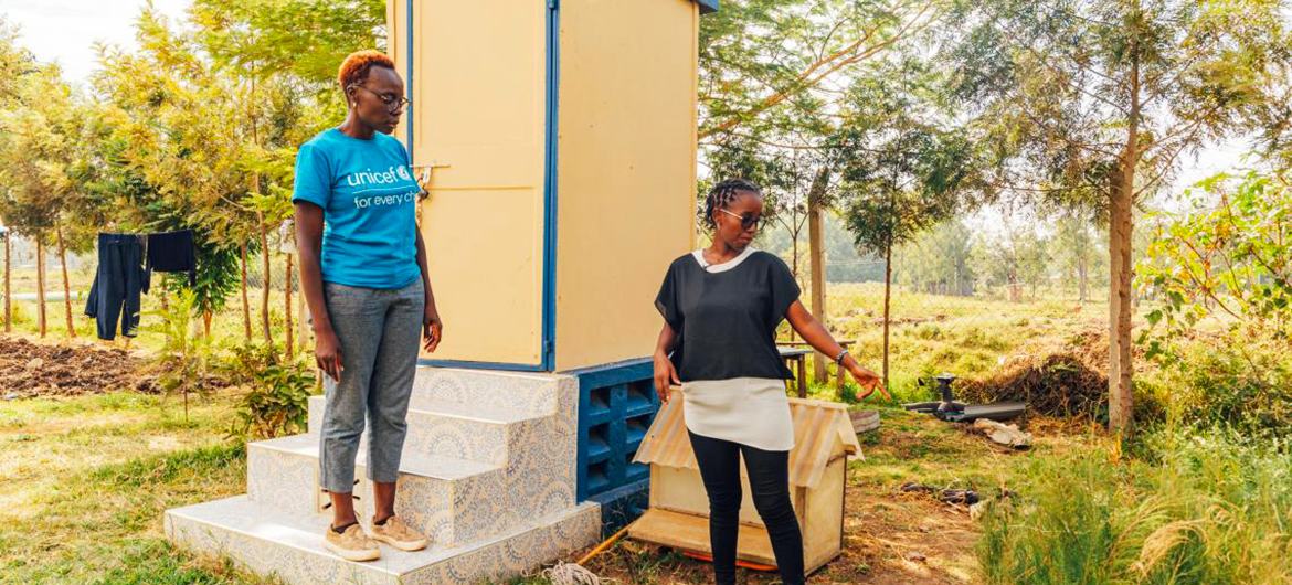 Chelsea Johannes (right) explains how the Saniwise Technologies eco-toilet works. 